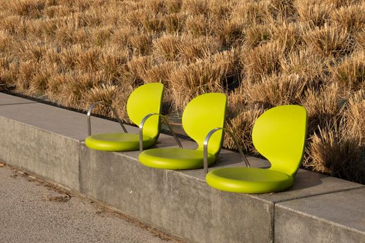 Close-up of three chairs on the street walkway in the park for people sitting and relaxing on holidays or vacations for your background or your design. Travel and lifestyle concept.