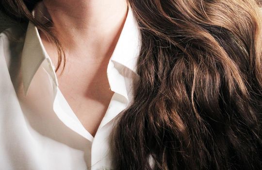 A beautiful girl in a white shirt with loose long dark hair..