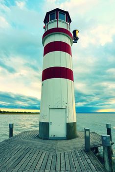 Romantic evening walk on wooden mole to Lighthouse at Lake Neusiedl (Podersdorf am See) at sunset, Burgenland, Austria