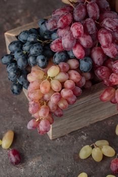 Grapes in a wooden box on a dark background