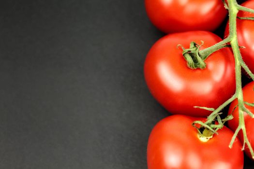 Red tomatoes on white plate with water drops