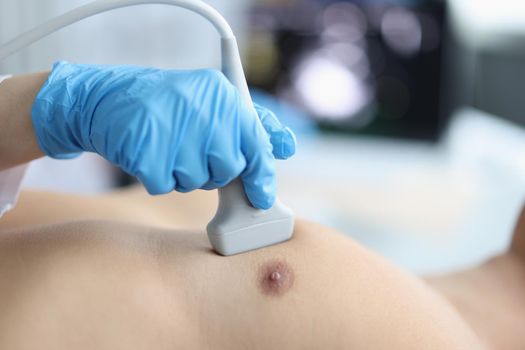 Close-up of medical worker investigating man heart, patient on appointment in clinic. Person on planned checkup in hospital. Ultrasound, diagnostic concept