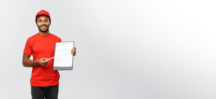 Delivery Concept - Portrait of Handsome African American delivery man or courier showing a confirmation document form to sign. Isolated on Grey studio Background. Copy Space