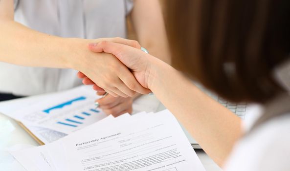 Close-up of partners shaking hands over business contract in company, biz partners confirm successful agreement. Career growth, celebrate, deal concept