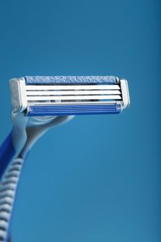 Blades of a new shaving machine on a blue background close-up free space