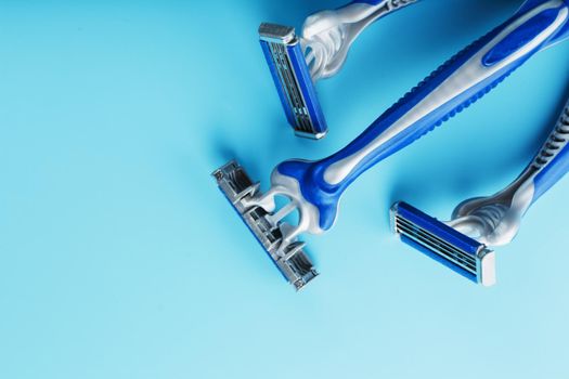 Blue shaving machine with sharp blades on the background of ice cubes close-up. The concept of cleanliness and frosty freshness