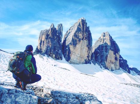Man hiker with backpack on the Tre Cime di Lavaredo tour. beautiful surroundings at spring time, Dolomites in Italy, Europe 