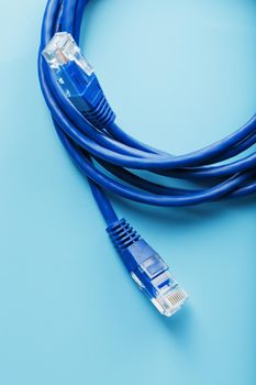 Blue Ethernet Cable Connectors Patch cord cord close-up isolated on a blue background with free space