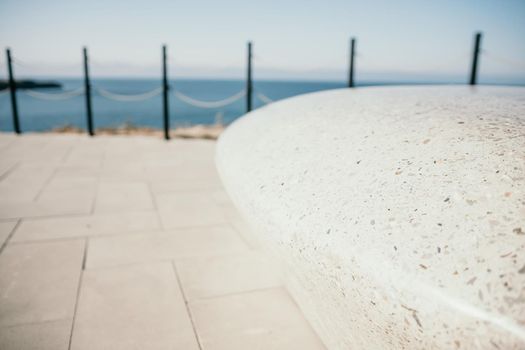 Sea side public park with concreate bench in spring evening.