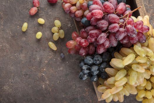 Grapes in a wooden box on a dark background