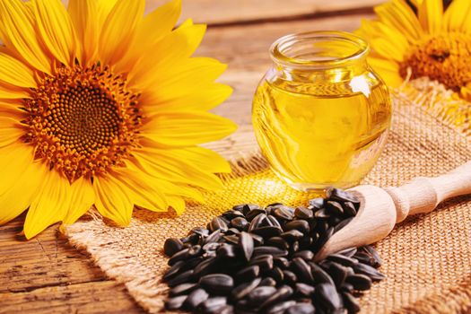 Sunflower seeds and oil bottle on old wooden background. Selective focus.nature