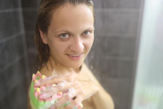 Portrait of young woman take hot shower after hard day, cleansing with washcloth. Female topless enjoying running water, release tension. Hygiene concept