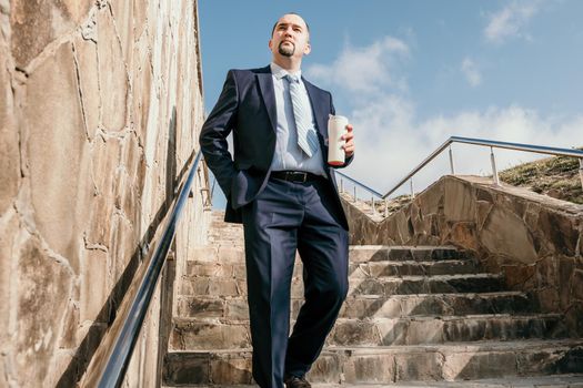 Business executive with briefcase going down the stairs.
