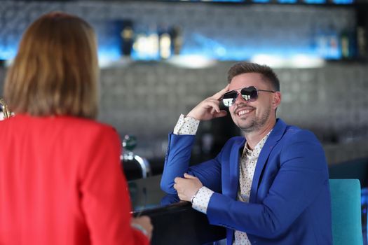 Portrait of stylish dressed man meeting with woman colleague, go for drink in bar. Successful people on business meeting. Businesspeople, lunch concept