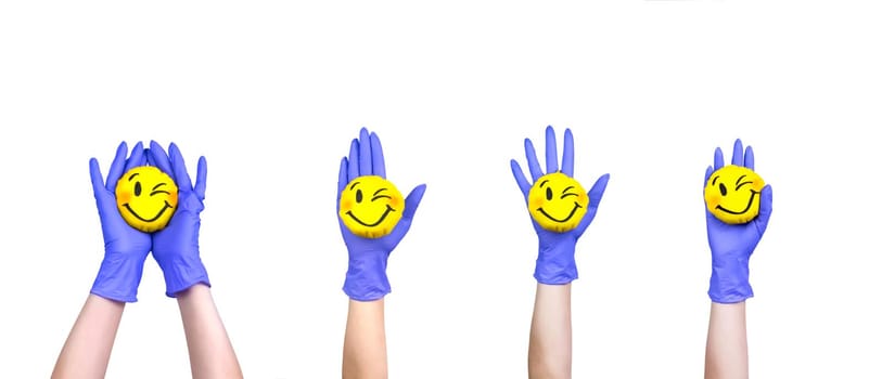 Hands in a medical gloves holding the smiling toy. Happy smile in our hands.