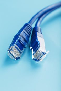 Blue Ethernet Cable Connectors Patch cord cord close-up isolated on a blue background with free space