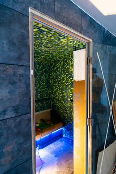 Building a Turkish-style sauna at home. Stylish green mosaic steam spa room. Sauna room interior design with mosaic tile.