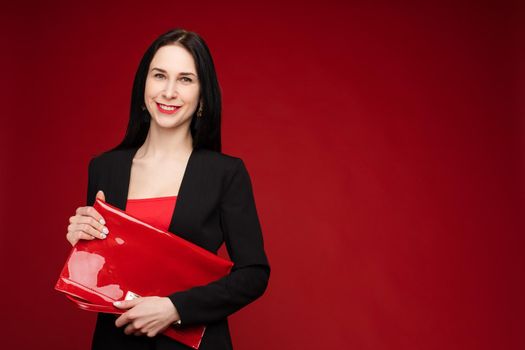 Portrait of young beautiful woman thoughtfully looking down. Brunette model in elegant costume posing at camera . Pretty lady in red sunglasses leaning one hand on other and holding it near face.