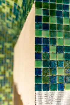 Green mosaic tiles on wall, small ceramic tiles. Sauna renovation concept