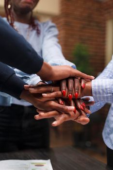 Marketing company employees celebrating successful startup project results and financial growth. African american financial department team putting their hands together to celebrate business success.