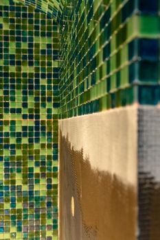 Wall covered with green mosaic ceramic tiles