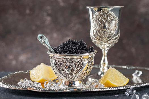 Black Caviar in a silver bowl on a dark background