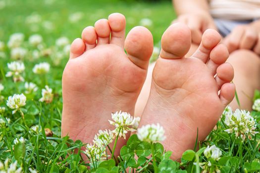 Baby feet on the green grass. Selective focus. nature.