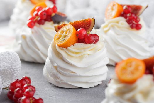 Pavlova dessert with berries on a gray background