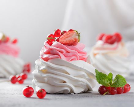 Pavlova dessert with berries on a gray background