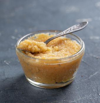 Pike Caviar with a spoon in a glass bowl on a blie background