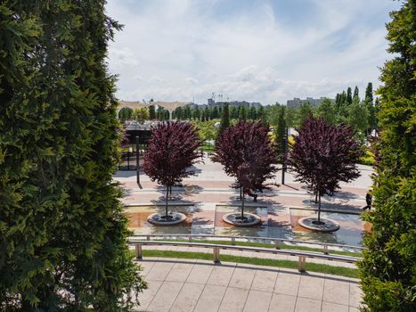 KRASNODAR, RUSSIA - June 01, 2021. People have rest in shadows of trees and on alleys in modern public park Krasnodar.