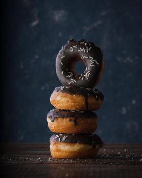 Donuts with dark and white chocolate on a dark background