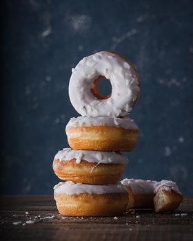 Donuts with dark and white chocolate on a dark background