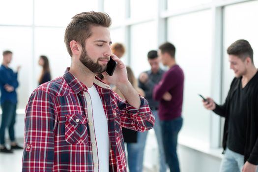 close up. smiling young designer reading a message on his smartphone