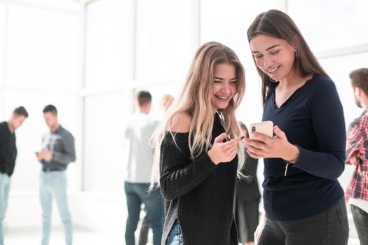 two young colleagues looking at the smartphone screen . office workdays