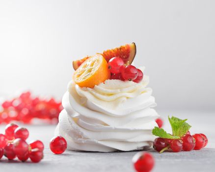 Pavlova dessert with berries on a gray background