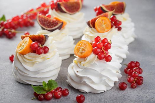 Pavlova dessert with berries on a gray background