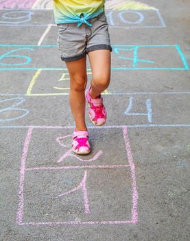 Child jumping classics on the pavement. Selective focus.child