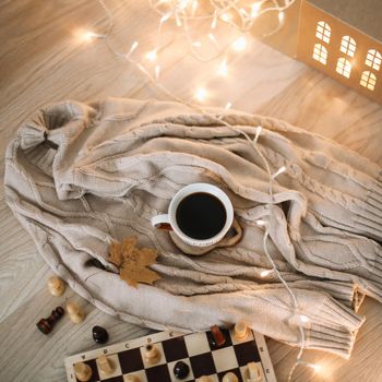 a cup of coffee on a knitted beige plaid