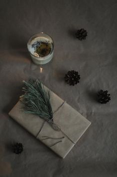 Christmas composition. Gift, fir tree branches, balls on craft paper background. Christmas, winter, new year concept. Flat lay, top view, copy space.