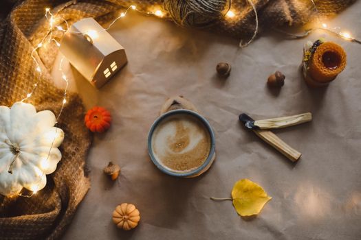 Autumn still life details in cozy home interior with a cup, candles, plaid. Hygge home decor. Halloween and Thanksgiving concept. Autumn banner