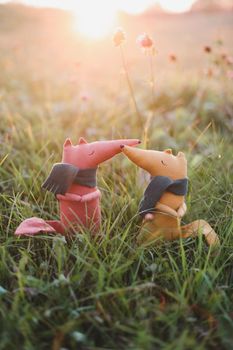 Cute little handmade toy fox in green grass. Childhood, baby, holiday, people, hobby, emotions concepts. High quality photo