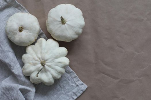 Autumn frame made of white pumpkins and squash on craft paper background. Fall, Halloween, Thanksgiving concept. Top view, copy space.