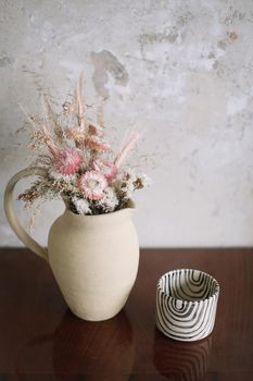 home decor with a ceramic jug with flowers and a cup. interior details.