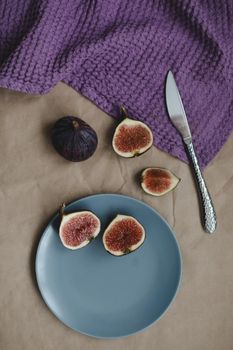 still life with ripe fresh figs and purple textiles on rustic background, flatlay, overhead view