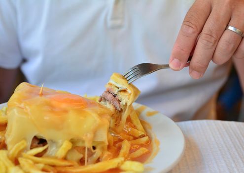 A portuguese sandwich Francesinha served with french fries original dish in Porto, Portugal
