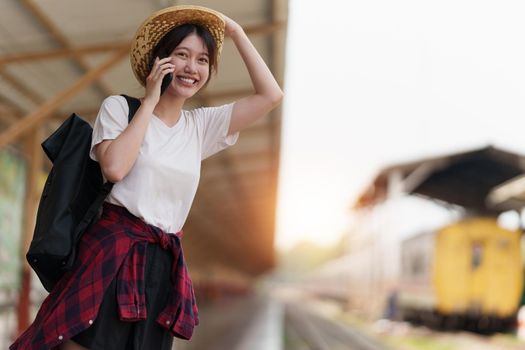Young traveler woman looking for friend planning trip at train station. Summer and travel lifestyle concept