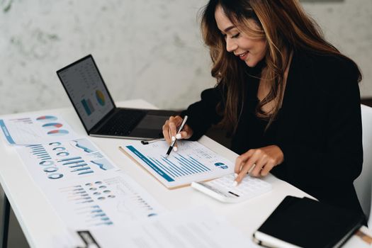 usiness analyzing investment charts with calculator laptop. Accounting and technology in office.Business people using laptop at office,Analyze plans.selective focus