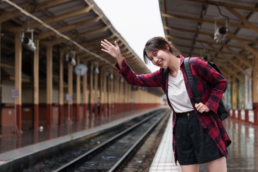 Beautiful traveler with backpack go to summer trip by train. Travel concept