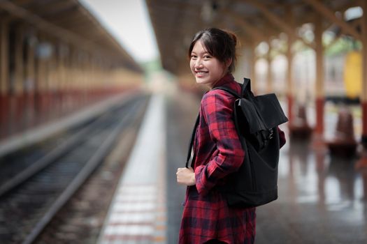 Beautiful traveler with backpack go to summer trip by train. Travel concept